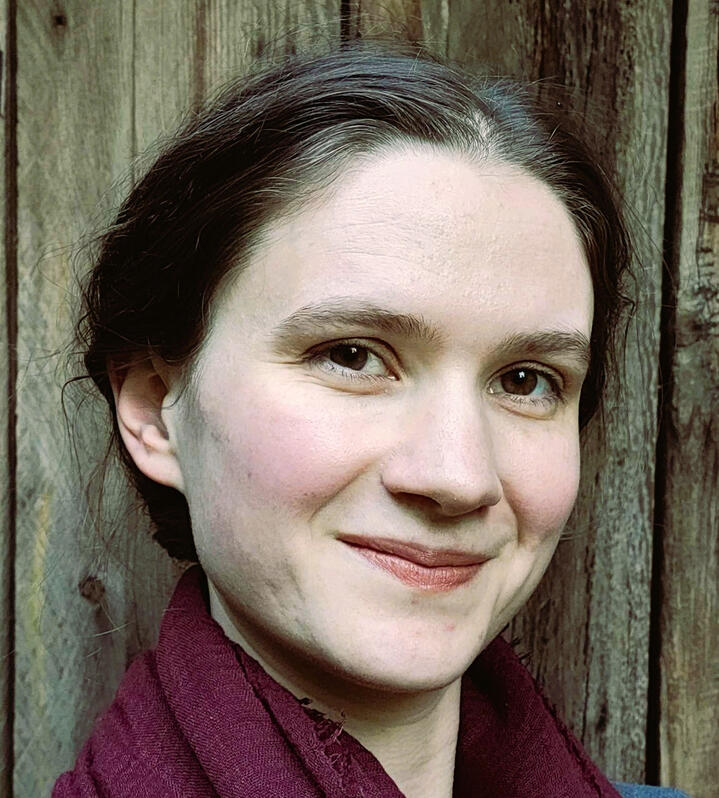 A head shot of the editor, Zoe, smiling at the camera